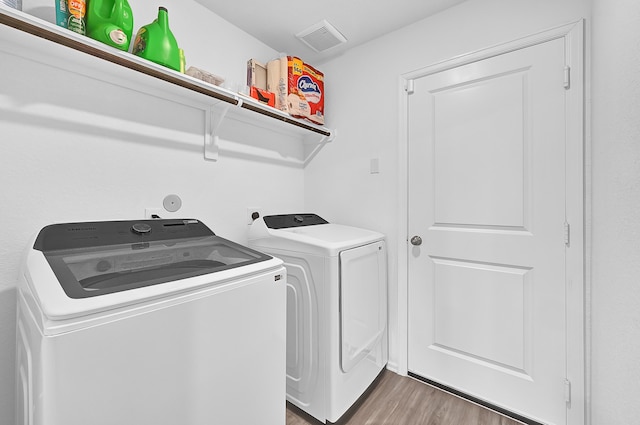 clothes washing area with dark hardwood / wood-style flooring and washer and dryer