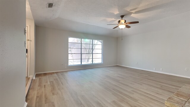 unfurnished room with ceiling fan, a textured ceiling, and light hardwood / wood-style flooring