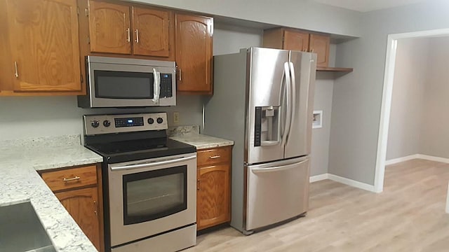 kitchen featuring light wood-type flooring and appliances with stainless steel finishes