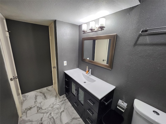 half bath featuring a textured ceiling, toilet, an inviting chandelier, marble finish floor, and vanity