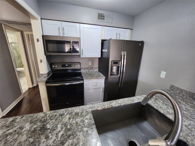 kitchen featuring sink, dark hardwood / wood-style flooring, light stone countertops, stainless steel appliances, and white cabinets