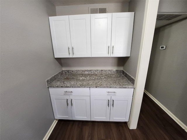 laundry room featuring visible vents, baseboards, and dark wood finished floors