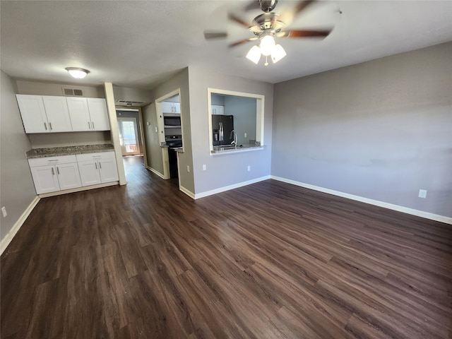 unfurnished living room featuring sink, ceiling fan, and dark hardwood / wood-style flooring