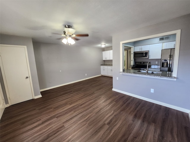 unfurnished living room with sink, ceiling fan, and dark hardwood / wood-style flooring