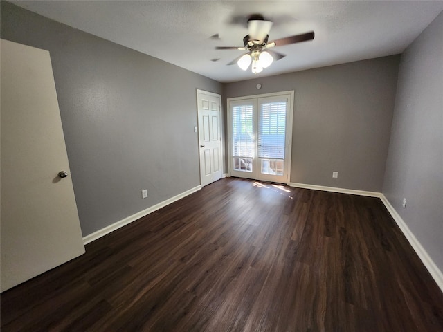 unfurnished room with a ceiling fan, baseboards, and dark wood-style floors