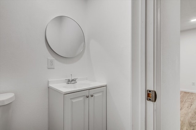 bathroom with vanity, toilet, and wood-type flooring