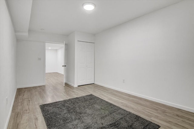 unfurnished bedroom with light wood-type flooring and a closet