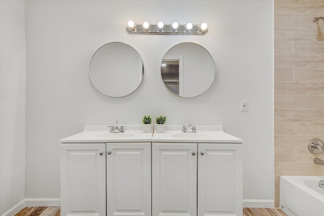 bathroom featuring hardwood / wood-style floors, vanity, and tiled shower / bath