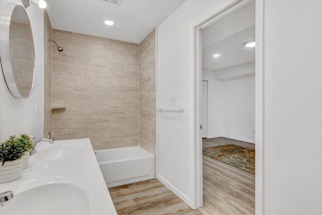 bathroom featuring vanity, hardwood / wood-style flooring, and tiled shower / bath