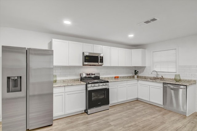 kitchen with sink, light wood-type flooring, white cabinetry, and stainless steel appliances