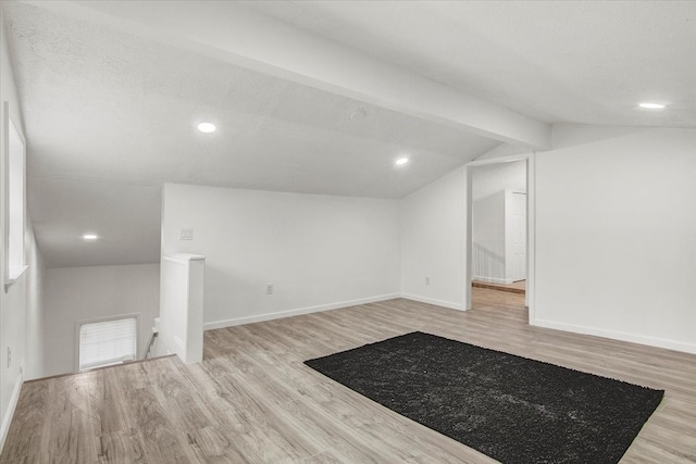 basement with a textured ceiling and light hardwood / wood-style flooring