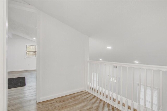 interior space with light hardwood / wood-style floors and vaulted ceiling