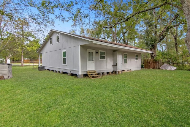 rear view of house featuring a lawn and central AC unit