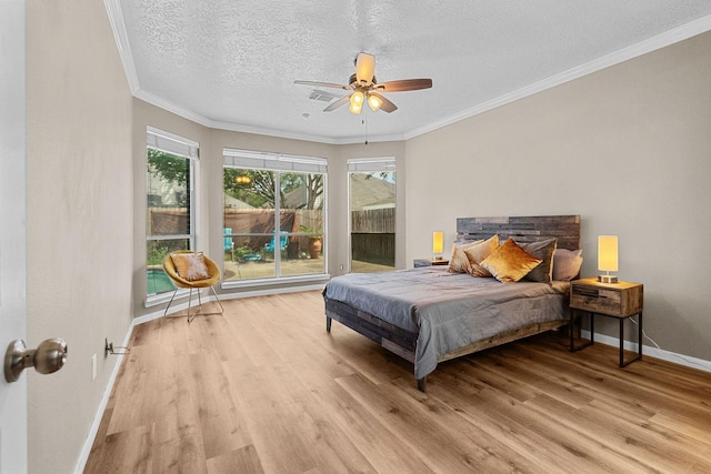 bedroom featuring crown molding, light wood-style floors, a ceiling fan, a textured ceiling, and baseboards