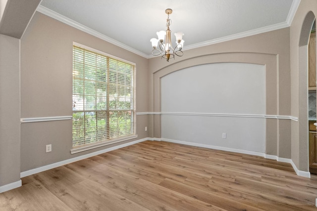 unfurnished room with light wood finished floors, baseboards, arched walkways, ornamental molding, and an inviting chandelier