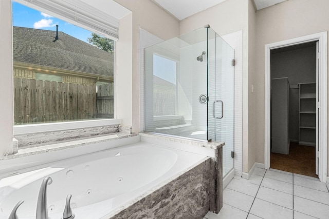 bathroom with a tub with jets, tile patterned flooring, and a shower stall