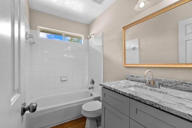 bathroom with visible vents, toilet, tub / shower combination, vanity, and wood finished floors