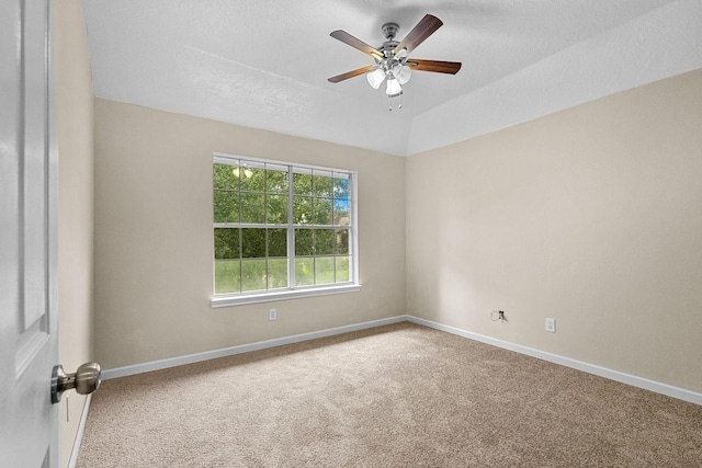 carpeted spare room with lofted ceiling, ceiling fan, a textured ceiling, and baseboards