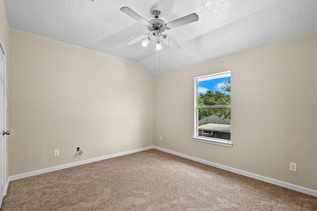 carpeted empty room with a ceiling fan, vaulted ceiling, a textured ceiling, and baseboards