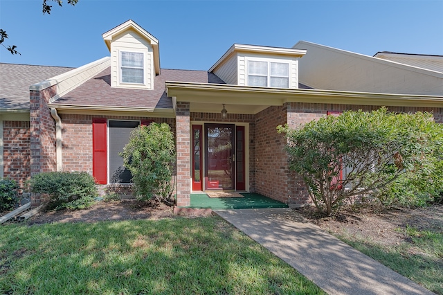 view of exterior entry with a yard