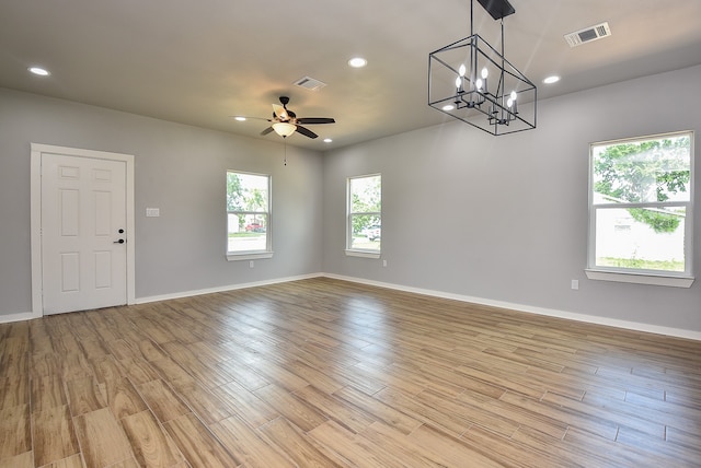 unfurnished room featuring light hardwood / wood-style floors and ceiling fan with notable chandelier