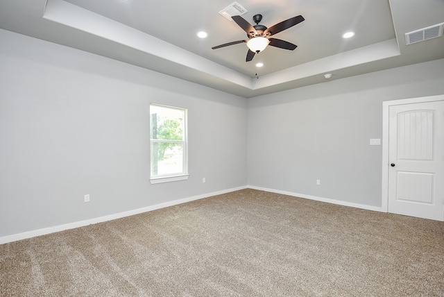 unfurnished room featuring ceiling fan, carpet, and a tray ceiling