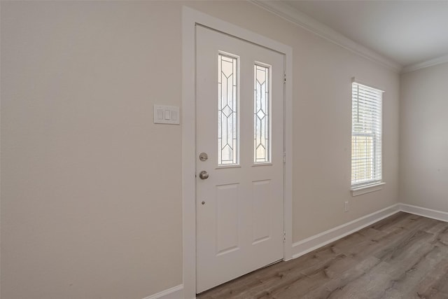 entrance foyer with crown molding, wood finished floors, and baseboards