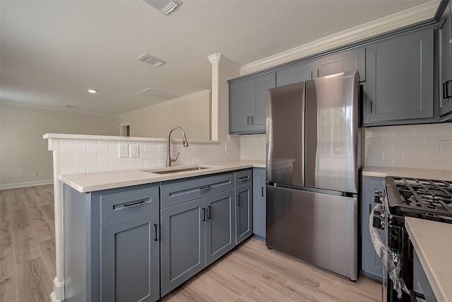 kitchen with decorative backsplash, light wood-type flooring, ornamental molding, sink, and stainless steel appliances