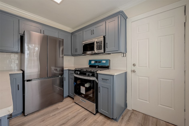 kitchen featuring light wood-type flooring, gray cabinetry, decorative backsplash, and stainless steel appliances