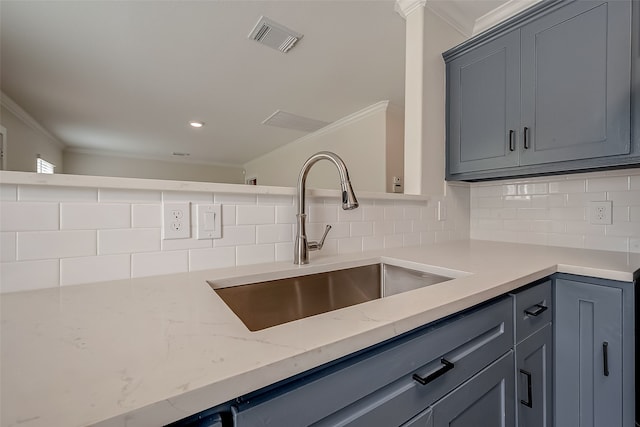 kitchen with sink, decorative backsplash, crown molding, and light stone counters