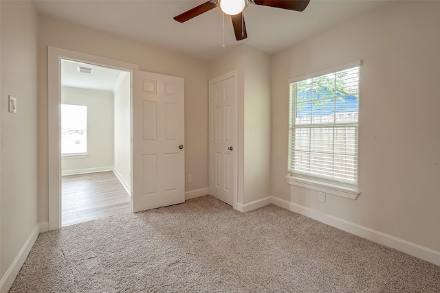 unfurnished bedroom featuring ceiling fan and light carpet