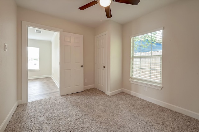 unfurnished bedroom featuring a ceiling fan, carpet, visible vents, and baseboards