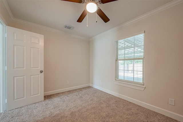 carpeted empty room featuring visible vents, baseboards, a ceiling fan, and crown molding