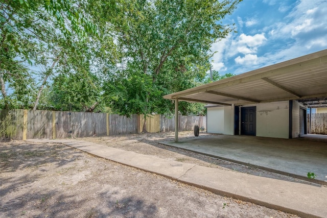 exterior space with an attached carport and fence