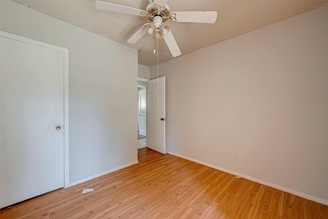 unfurnished bedroom with ceiling fan, light wood finished floors, and baseboards