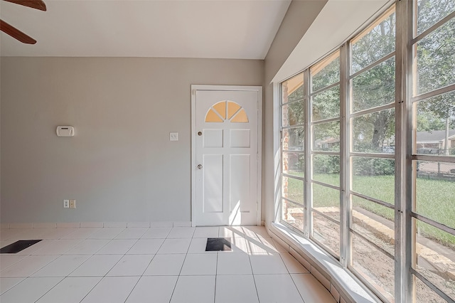 foyer entrance with a healthy amount of sunlight, ceiling fan, and tile patterned floors