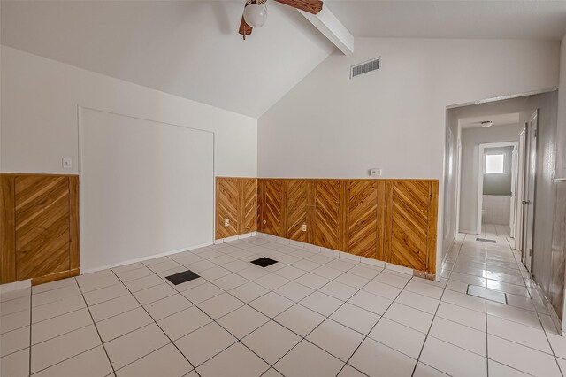 additional living space with vaulted ceiling with beams, visible vents, a ceiling fan, wainscoting, and tile patterned flooring