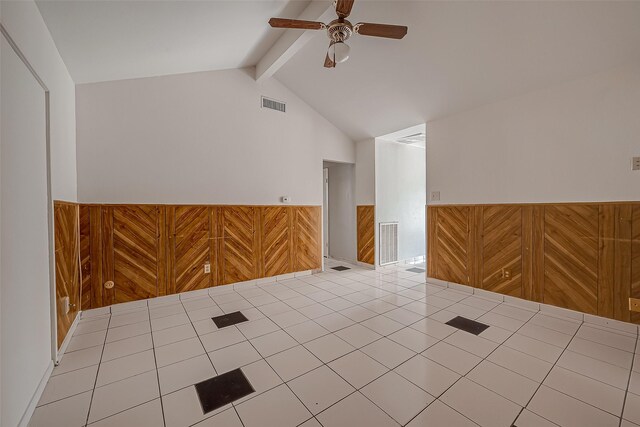 tiled spare room with lofted ceiling with beams, ceiling fan, wainscoting, and visible vents