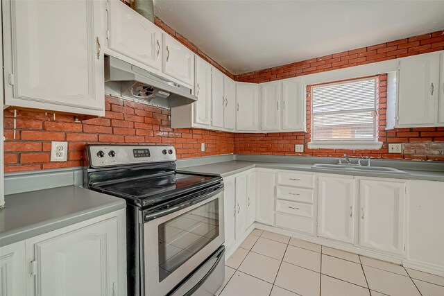 kitchen with white cabinets, a sink, under cabinet range hood, and stainless steel electric range