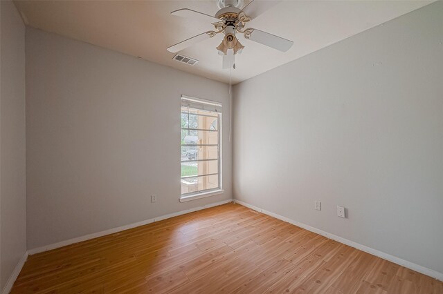 empty room with visible vents, light wood-style flooring, and baseboards