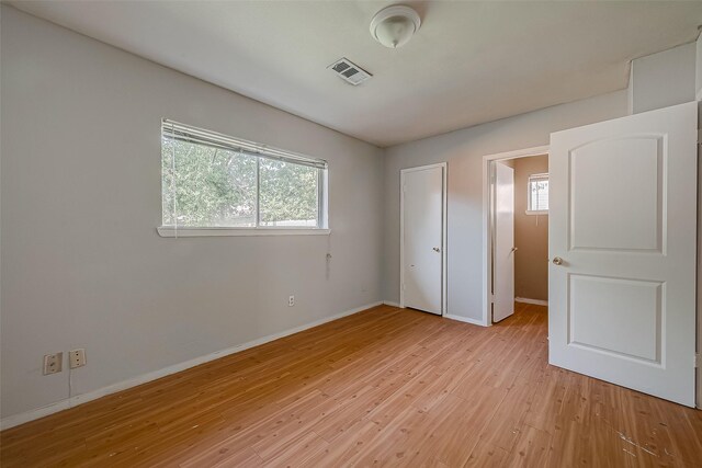 unfurnished bedroom featuring light wood-type flooring, visible vents, and baseboards