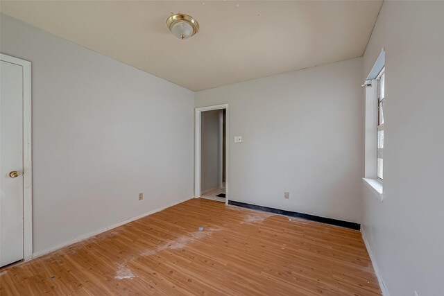 spare room featuring light wood-style floors and baseboards