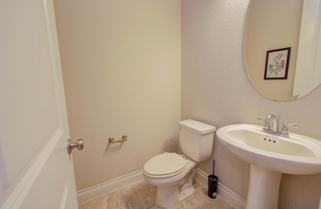 bathroom with toilet and tile patterned floors