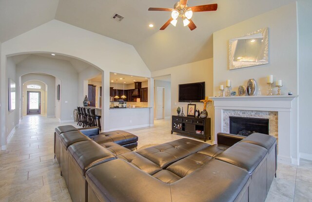 tiled living room featuring ceiling fan and vaulted ceiling