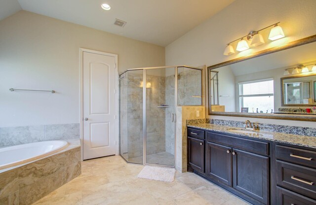 bathroom featuring tile patterned flooring, vaulted ceiling, separate shower and tub, and vanity