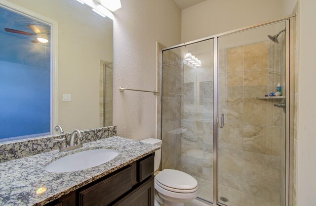 bathroom featuring an enclosed shower, toilet, and vanity