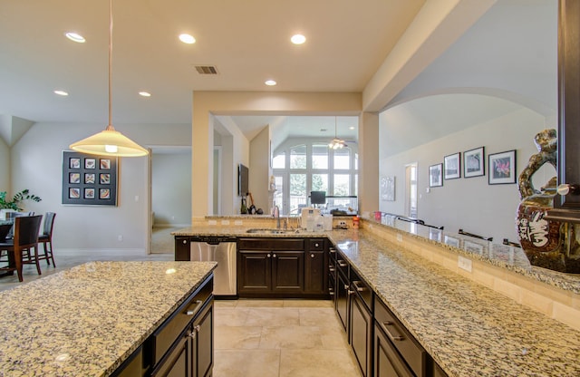 kitchen featuring light tile patterned flooring, hanging light fixtures, stainless steel dishwasher, and light stone counters