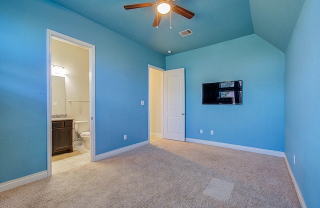 unfurnished bedroom featuring ceiling fan, vaulted ceiling, and light colored carpet