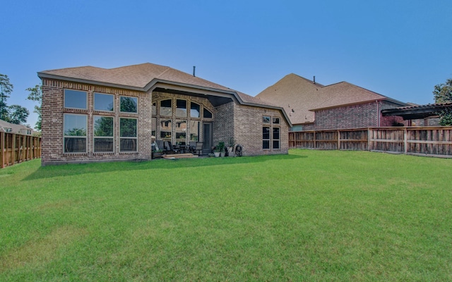 rear view of property featuring a lawn