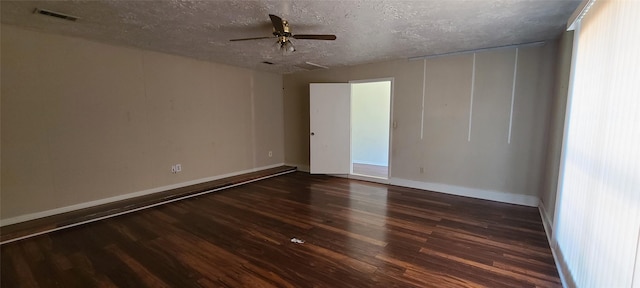 empty room with ceiling fan, a textured ceiling, visible vents, and dark wood-style flooring